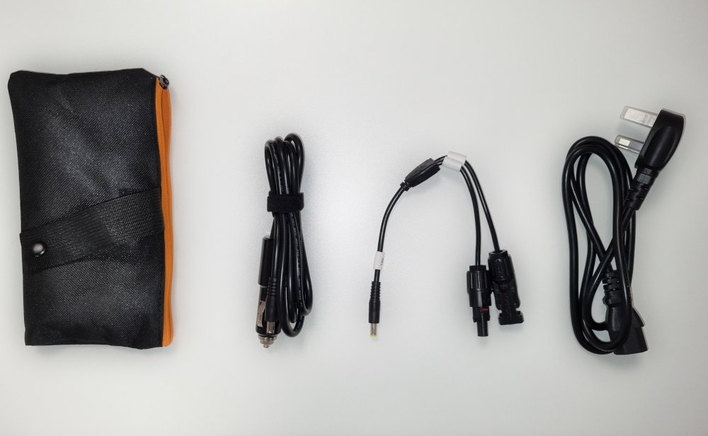 Overhead view of car charge, solar adapter and mains charge leads with accessory bag